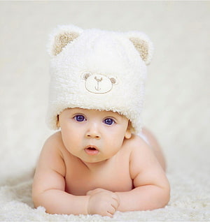 Adorable Baby Boy Wearing a Fluffy White Bear Hat Lying on a Soft Blanket HD phone wallpaper