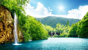 Serene Waterfall Cascading Into Turquoise Lake Surrounded By Lush Green Forest HD wallpaper