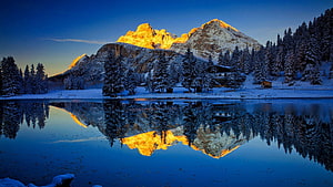 Alpine Lake Reflection at Sunrise with Snow-Covered Peaks and Evergreen Forest HD wallpaper