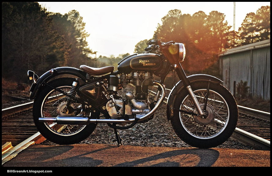 Classic Royal Enfield Bullet Motorcycle Parked on Rustic Railroad Tracks at Golden Hour HD wallpaper