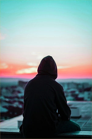 Silhouette of a Hooded Figure Sitting on a Rooftop Watching a Colorful Sunset HD phone wallpaper
