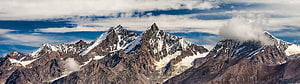 Majestic Snow-Capped Mountain Peaks Rising Above Clouds in a Dramatic Alpine Landscape HD wallpaper