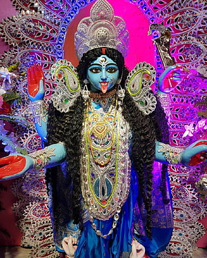 Maa Kali Thakur with ornate silver crown and elaborate jewelry against vibrant pink mandala backdrop HD phone wallpaper