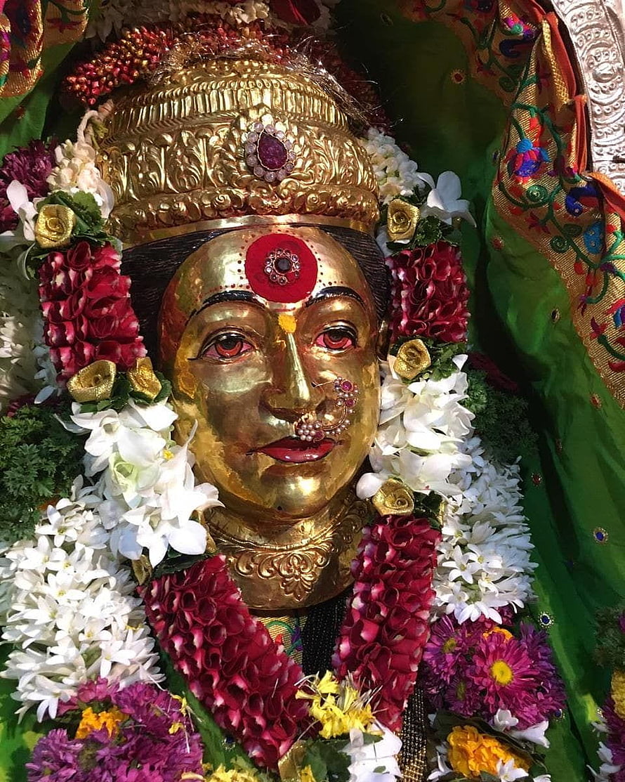 Golden Goddess Statue Adorned with Floral Garlands and Traditional Jewelry HD phone wallpaper