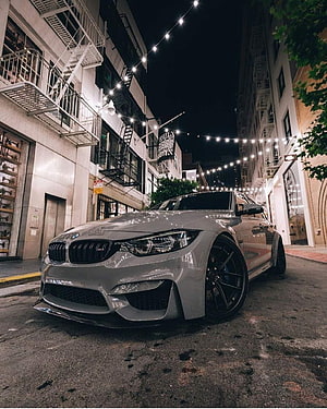 Silver BMW M3 F80 Sedan Parked on Urban Street at Night with String Lights HD phone wallpaper