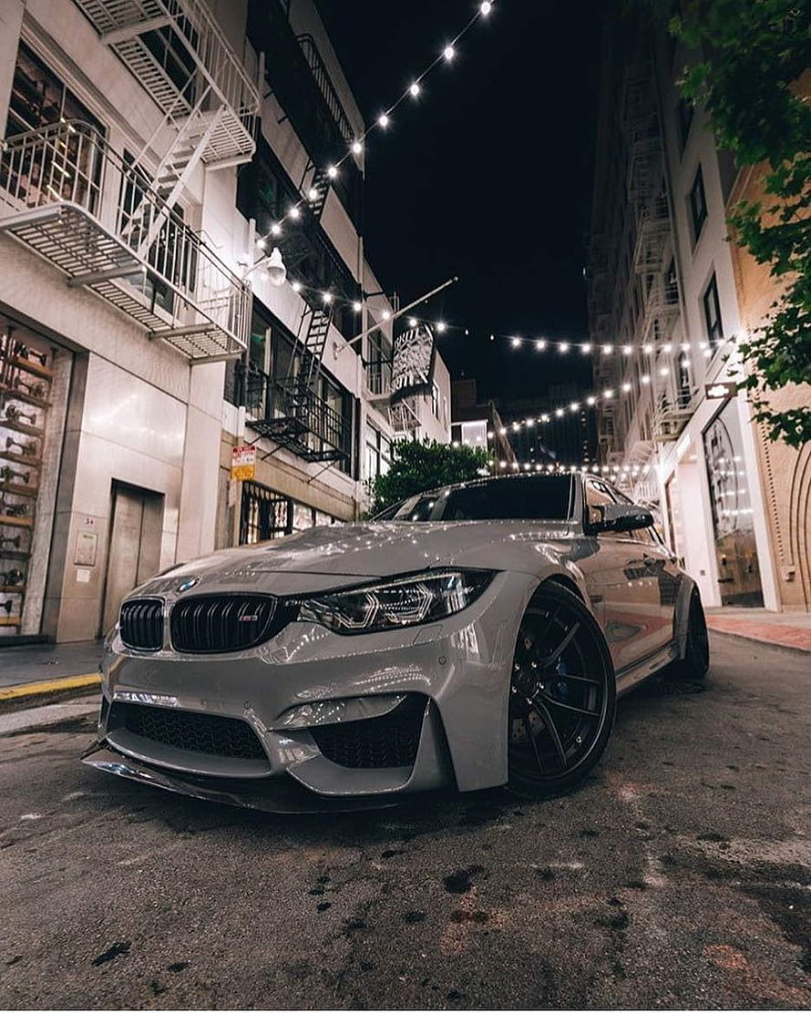 Silver BMW M3 F80 Sedan Parked on Urban Street at Night with String Lights HD phone wallpaper