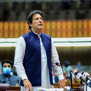 Imran Khan speaking at a podium in the parliament wearing a blue vest HD phone wallpaper