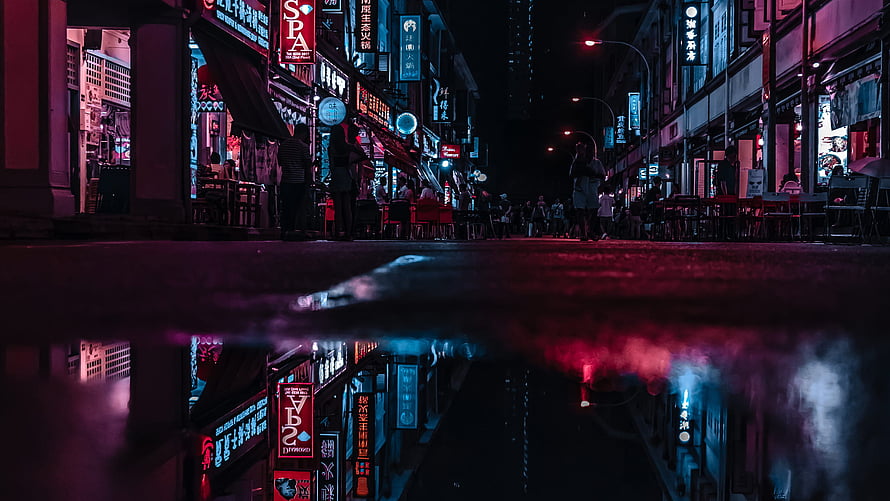 Neon-lit Asian street at night with vivid reflections in a rain puddle HD wallpaper