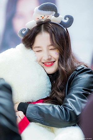 Nancy from MOMOLAND smiling warmly while hugging a plush toy in a black leather jacket HD phone wallpaper