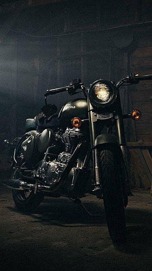 Royal Enfield Bullet Standard motorcycle parked in a dimly lit garage with dramatic lighting HD phone wallpaper