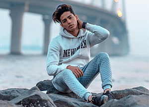 Danish Zehen Sitting on Beach Rocks Wearing White New York Hoodie HD wallpaper