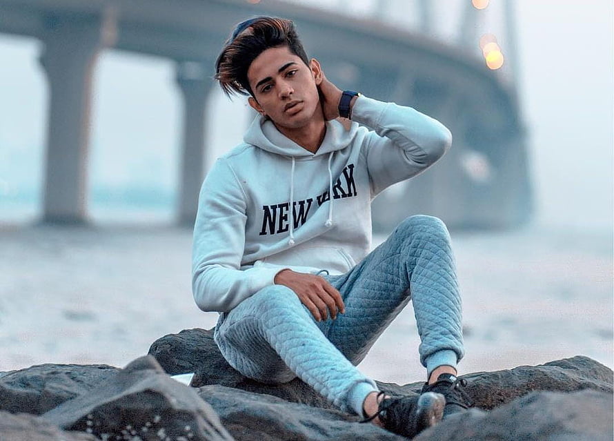 Danish Zehen Sitting on Beach Rocks Wearing White New York Hoodie HD wallpaper
