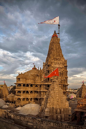Khajuraho Group of Monuments ancient Indian temple architecture with intricate stone carvings and flags against a dramatic cloudy sky HD phone wallpaper