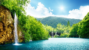 Serene Waterfall Cascading Into Turquoise Lake Surrounded By Lush Green Forest HD wallpaper