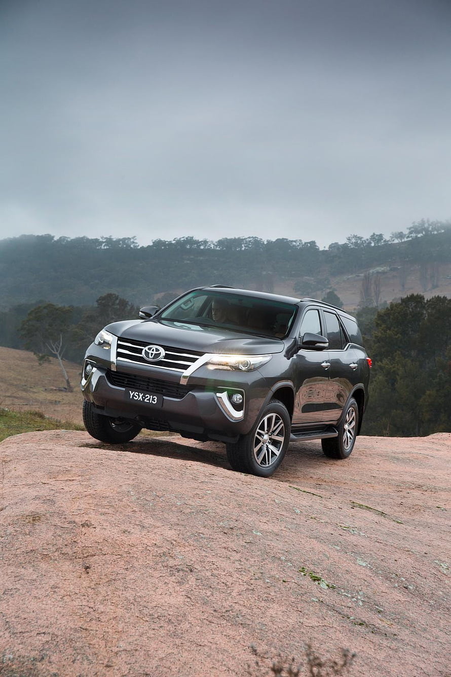 Dark Grey Toyota Fortuner SUV Parked on Rocky Outcrop with Forest Background HD phone wallpaper