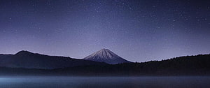 Snow-Capped Mountain Under a Starry Night Sky with Misty Lake Foreground HD wallpaper