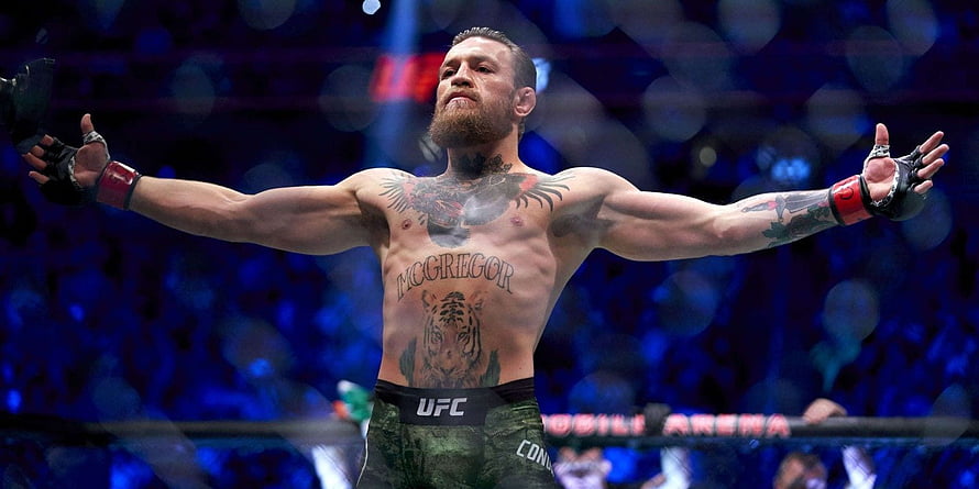 Conor McGregor Celebrating Victory in the UFC Octagon with Arms Raised HD wallpaper
