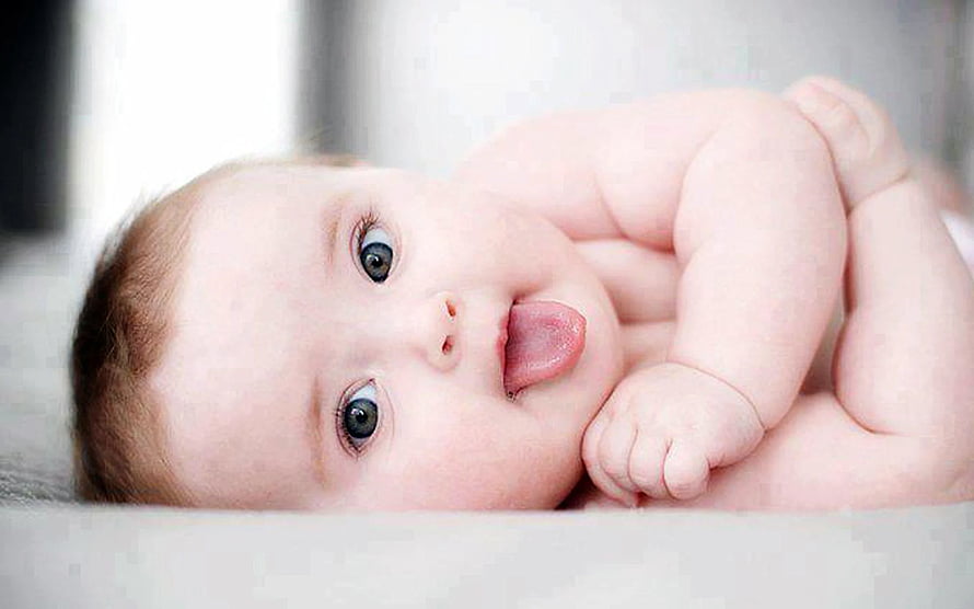 Cute Baby Lying Down With Tongue Out And Big Blue Eyes HD wallpaper