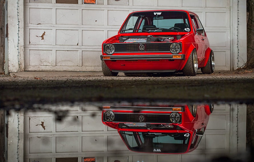 Red VW Golf MK1 Stance Build Parked in Front of Garage Door with Water Reflection HD wallpaper