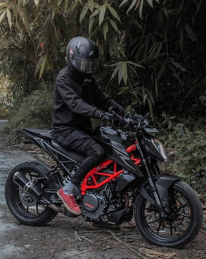 Rider on a Modified KTM Duke 250 with Red Frame in a Lush Forest Setting HD phone wallpaper