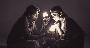 Couple Examining Solar Lamps in Dim Lighting HD wallpaper
