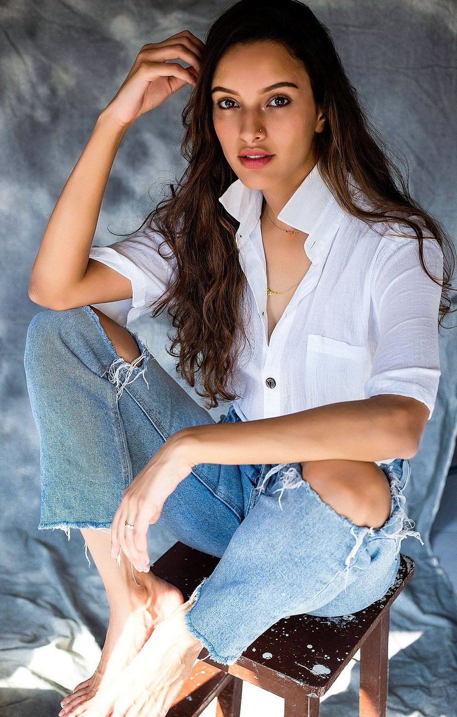 Tripti Dimri in White Shirt and Distressed Denim Sitting on a Stool HD phone wallpaper