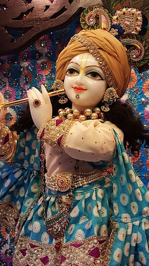 Ornate Krishna Idol Playing Flute with Peacock Feather Crown and Blue Attire HD phone wallpaper