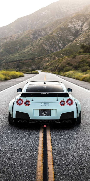 Rear View of a Mint Green Nissan GT-R R35 on a Winding Mountain Road HD phone wallpaper