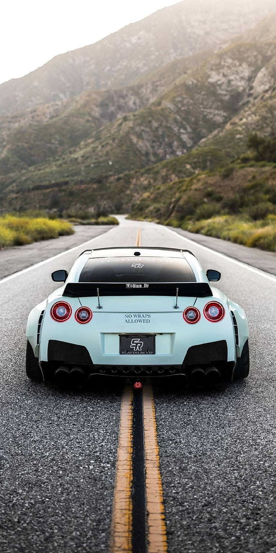 Rear View of a Mint Green Nissan GT-R R35 on a Winding Mountain Road HD phone wallpaper