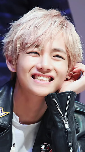 BTS V smiling in a black leather jacket with platinum blonde hair HD phone wallpaper