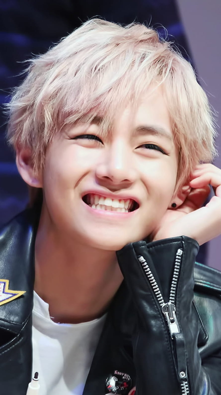 BTS V smiling in a black leather jacket with platinum blonde hair HD phone wallpaper