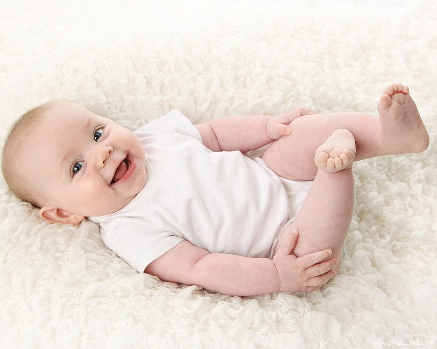 Smiling Baby Boy Lying on White Fluffy Blanket in White Onesie HD wallpaper
