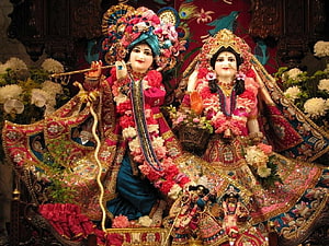 Radha Krishna Temple Deities Adorned in Vibrant Floral Garlands and Ornate Traditional Attire HD wallpaper