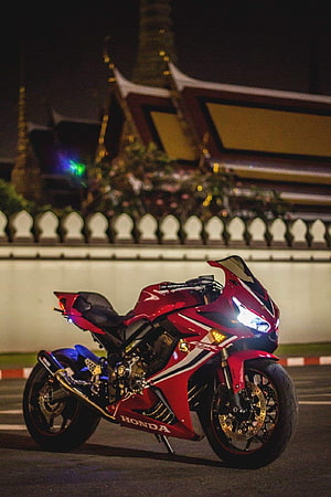 Red Honda CBR650R Sportbike Parked at Night in Front of Thai Temple HD phone wallpaper