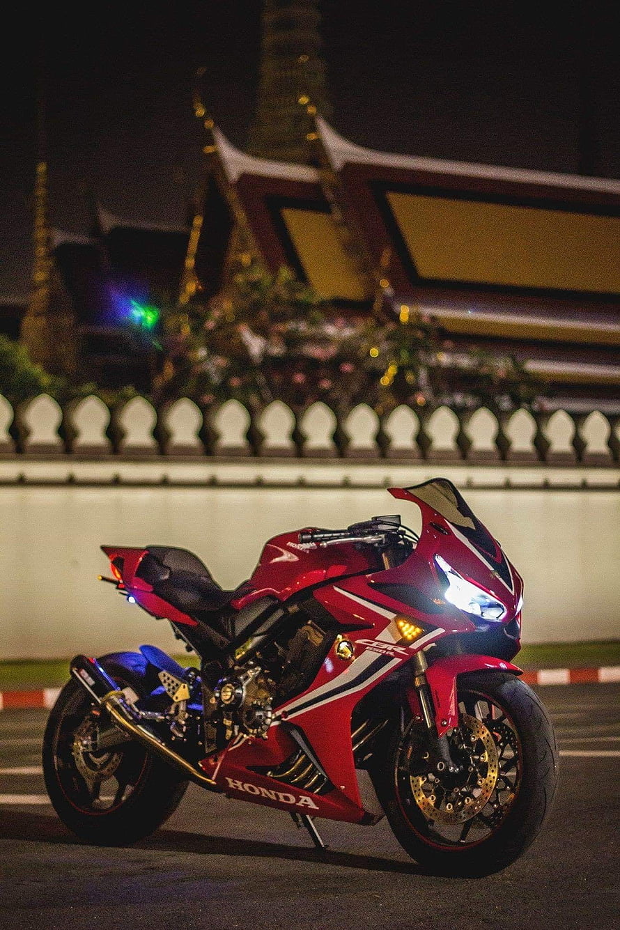 Red Honda CBR650R Sportbike Parked at Night in Front of Thai Temple HD phone wallpaper