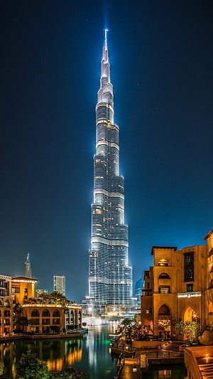 Burj Khalifa Illuminated at Night Over Dubai Canal with Warm Architectural Reflections HD phone wallpaper