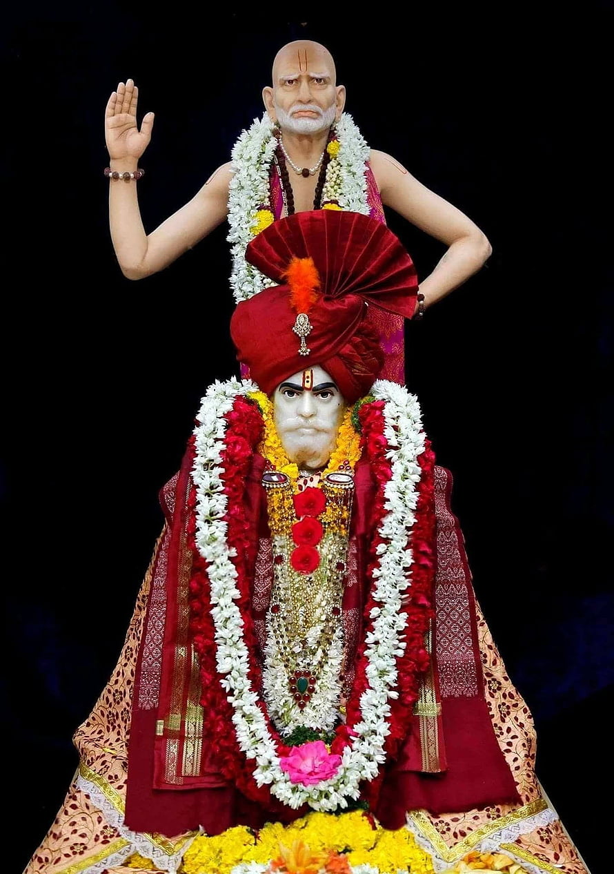 Traditional Indian Priest Performing Rituals with Decorated Deity Statue HD phone wallpaper