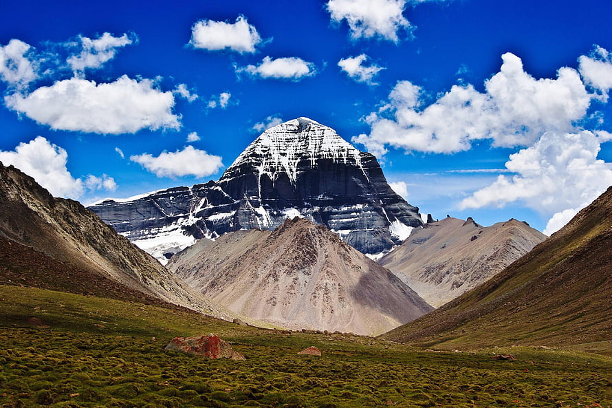 Mount Kailash Sacred Peak Rising Above High-Altitude Grasslands Under a Vivid Blue Sky HD wallpaper