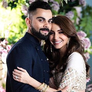 Virat Kohli and Anushka Sharma in an elegant embrace against a floral backdrop HD phone wallpaper