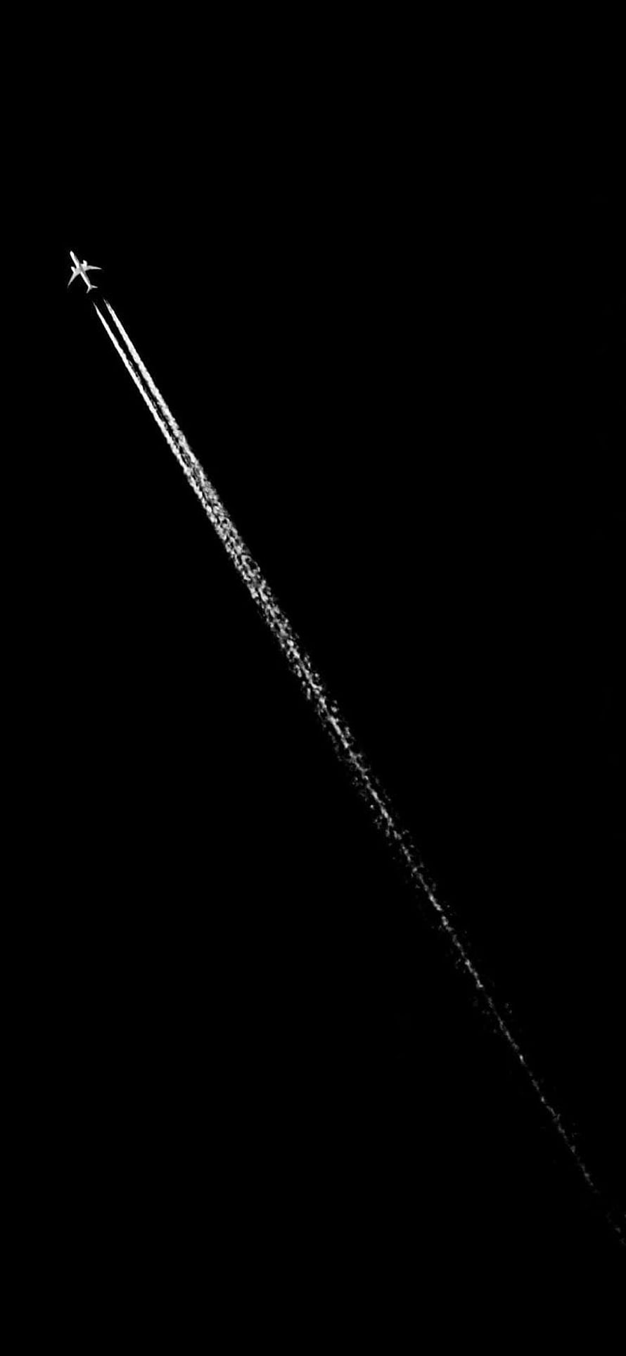 Minimalist airplane silhouette with long contrail against a pure black night sky HD phone wallpaper