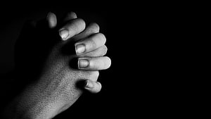 Black and White Close-Up of Interlaced Praying Hands Against a Dark Background HD wallpaper