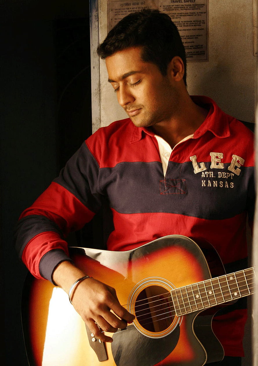 Bollywood actor playing acoustic guitar in red and blue striped polo shirt HD phone wallpaper
