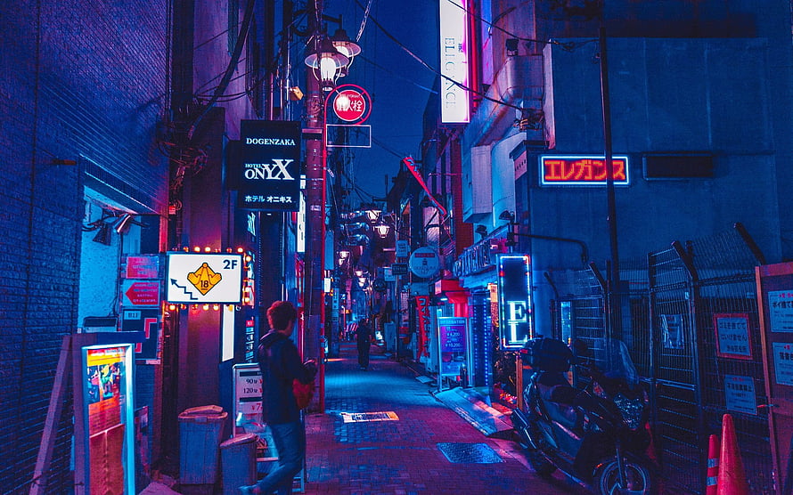 Neon-lit Tokyo alleyway at night with vibrant blue and pink lights, featuring a lone figure walking past glowing signs and a parked scooter in a cyberpunk-inspired urban scene HD wallpaper