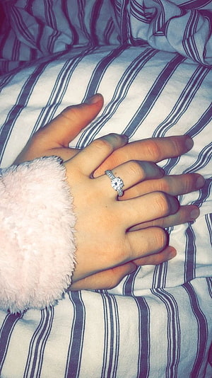 Couple Holding Hands With Diamond Engagement Ring on Striped Bedding HD phone wallpaper
