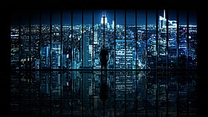 Silhouette of a businessman standing in a high-rise office overlooking a glowing blue city skyline at night, Ultra Windows, windows ultra HD wallpaper