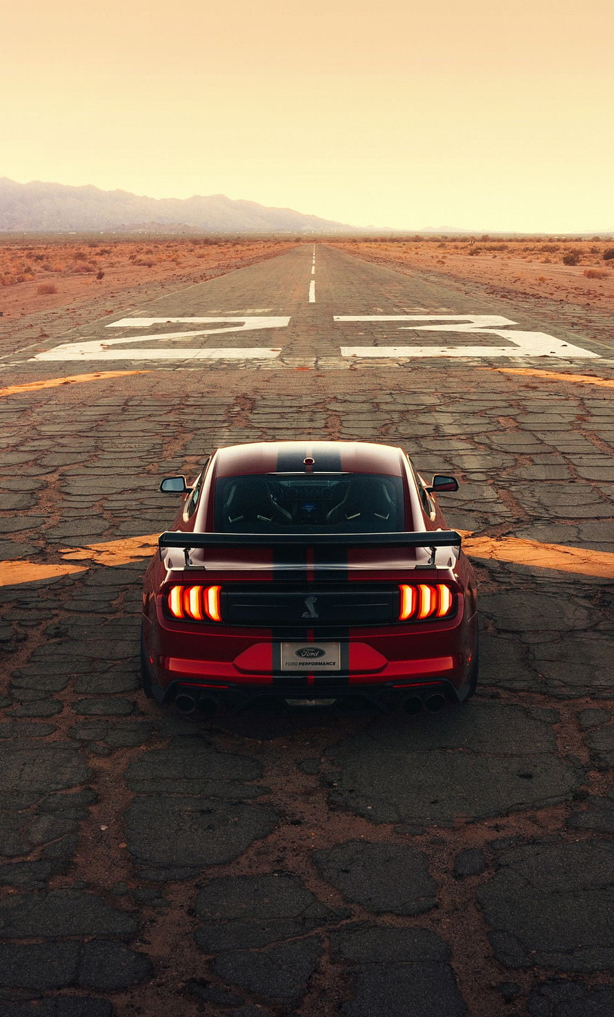 Rear View of a Red Ford Mustang Shelby GT500 on a Desert Runway at Sunset HD phone wallpaper