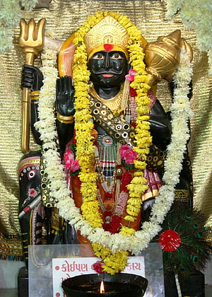 Black Statue of Lord Ayyappa Holding Trishul and Conch Shell with Flower Garlands HD phone wallpaper