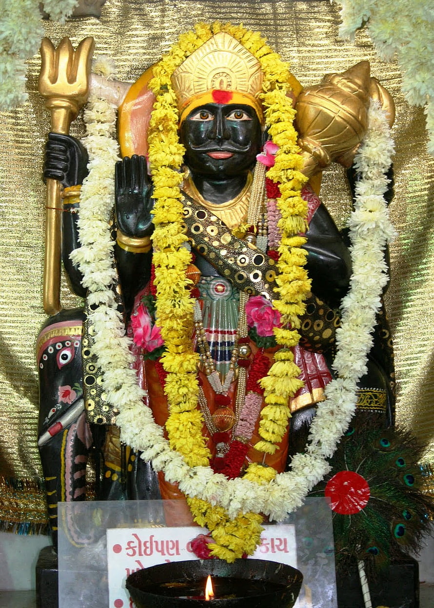 Black Statue of Lord Ayyappa Holding Trishul and Conch Shell with Flower Garlands HD phone wallpaper
