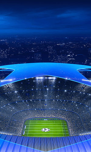 UEFA Champions League Stadium at Night with Glowing Blue Roof and City Skyline HD phone wallpaper