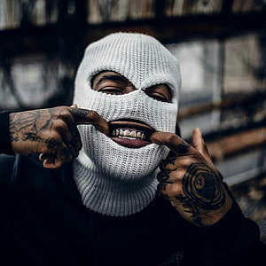 Portrait of a man wearing a white ski mask and gold grillz, pulling the mask down to reveal his smile with tattooed hands, Gangsta, gangster mask graffiti HD phone wallpaper
